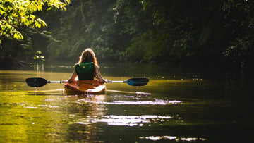 Kayaker paddles on a sunlit river