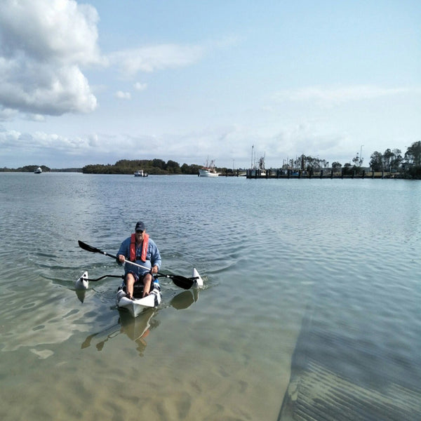 Man with fishing kayak and stabiliser outrigger kit