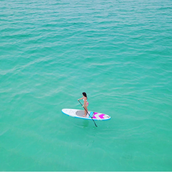 Lady paddling bay sports 10'6 EXPLORE inflatable paddle board on water